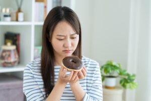砂糖入りお菓子を我慢する女性
