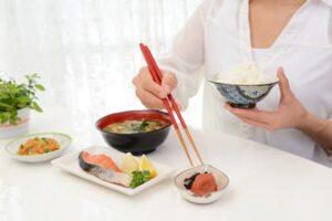 食事の時間を気にして食べる女性